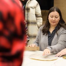 Group of students and staff gathered to learn how to make a drum