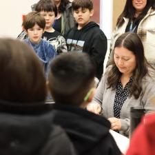 Students and staff watching a demonstration of making a drum.