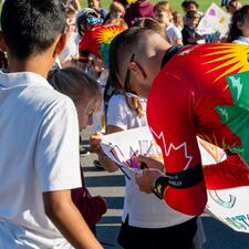 Tour de Valley rider signs a student made sign.